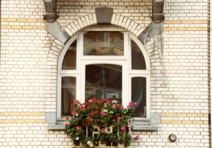 Rondboogvenster met centraal <a href='/nl/glossary/82' class='info'>Frans balkon<span>Borstwering tussen de dagkanten van een naar binnen openslaand venster dat tot de vloer doorloopt.</span></a> op benedenverdieping (foto 1993-1995).